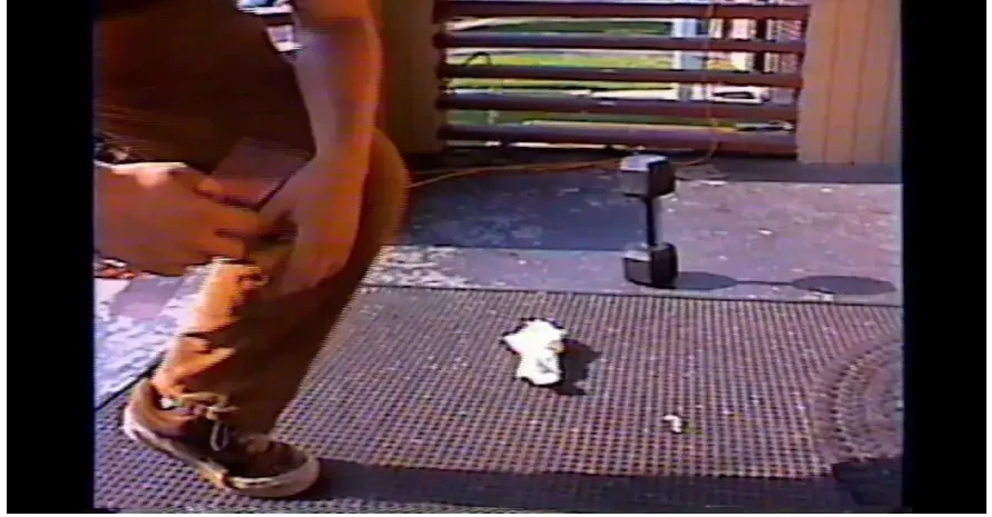 A frame from the bench test in our report: a foot beside the 30 lb dumbbell on a floor mat.